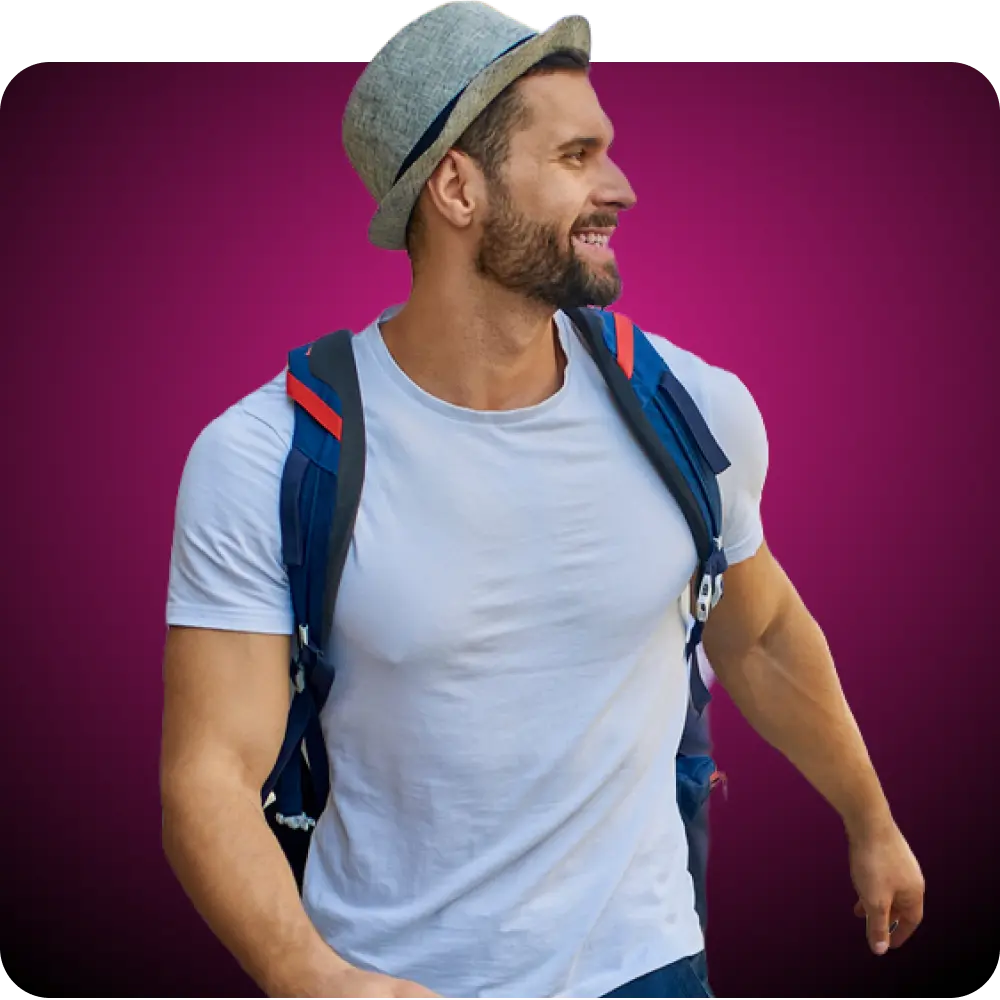 Man wearing a backpack and light blue tshirt looking to the right and smiling